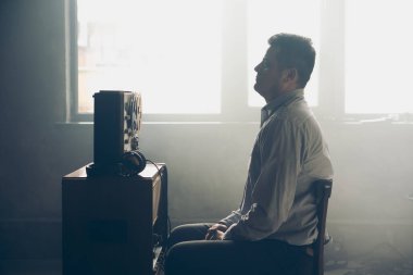 Gizli ajan kayıt cihazını dinliyormuş. Memur kulaklıkla dinleme yapıyor. Muhabbet casusluğu. İstihbarat toplama. Casusluk konsepti. Bilgileri üstlerinize bildirin.