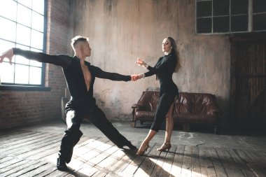 İki profesyonel balo dansçısı çatı katında dans ediyor. Güzel bir sanat gösterisi. Spor hayatı konsepti. Tutku ve duygusal dans.