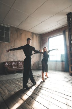 İki profesyonel balo dansçısı çatı katında dans ediyor. Güzel bir sanat gösterisi. Spor hayatı konsepti. Tutku ve duygusal dans.