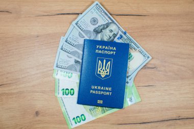 Ukrainian biometric passport id to travel the Europe with dollars and euros money on the table. Inscription in Ukrainian 