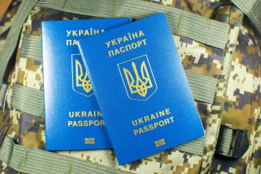 Ukrainian biometric passport on the military backpack. Ukrainian soldiers. Army concept. Stop war.