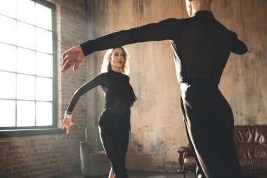 İki profesyonel balo dansçısı çatı katında dans ediyor. Güzel bir sanat gösterisi. Spor hayatı konsepti. Tutku ve duygusal dans.