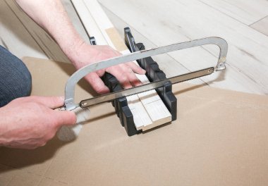 Man is installing the doors. Carpenter sawing wooden plank. Repair works. Maintenance in the apartment.