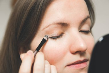 Kız makyaj yapıyor. Fırçayla göz farı. Güzellik fotoğrafı konsepti.