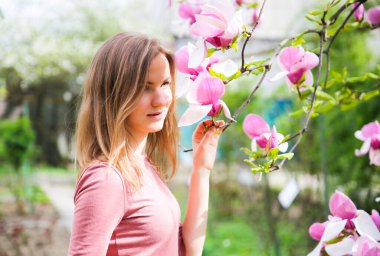 Çiçek açan ağacın yanında güzel bir kız. Açık havada manolya çiçeği. Bahar havası. Kadın dinleniyor..