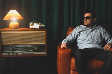 Eski kahverengi deri koltukta oturan özel ajan. Casusluk ya da istihbarat toplama. Casusluk konsepti. Bilgileri üstlerinize bildirin.