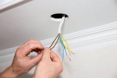 Adam elinde yapışkan bant tutuyor. Ampul için elektrik yalıtkan. Bakım onarımı dairede işe yarıyor. İçerideki restorasyon.