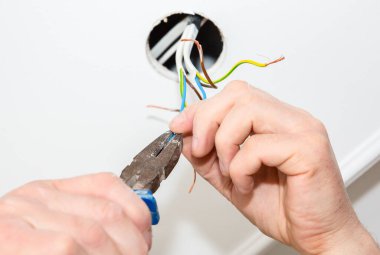 Adam elinde kerpeten tutuyor. Ampul için elektrik yalıtkan. Evde bakım onarımı için yapıştırıcı bant kullanılıyor. İçerideki restorasyon.