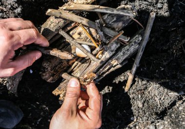 Adam katı alkolden ateş yapıyor. Doğada bir turist. Yemek hazırlamak için odun..