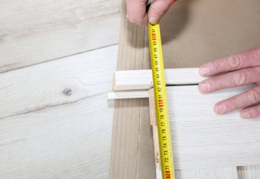 Man is installing the doors. Measure tape in hands. Repair works. Maintenance in the apartment.