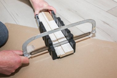 Man is installing the doors. Carpenter sawing wooden plank. Repair works. Maintenance in the apartment.