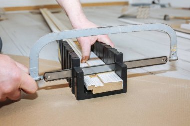 Man is installing the doors. Carpenter sawing wooden plank. Repair works. Maintenance in the apartment.