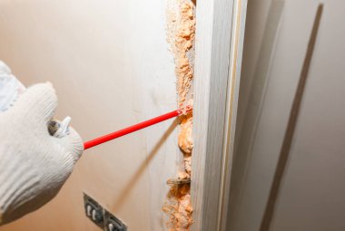 Adam sprey köpükle kapıyı kuruyor. Onarım işe yarıyor. Dairede bakım var..