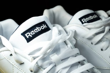 KYIV, UKRAINE - 20 Haziran 2022: Sarı arka planda Modern Reebok Klasik deri ayakkabılar. Sarı tabanlı beyaz deri ayakkabılar. Kapat..