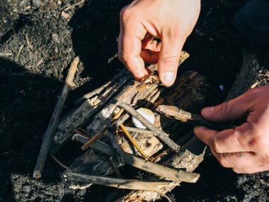 Adam katı alkolden ateş yapıyor. Doğada bir turist. Yemek hazırlamak için odun..