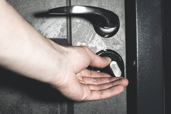 Человек закрывает или открывает дверной замок изнутри. Безопасность и защита от грабителей.