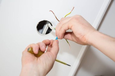 Adam elektrikli yalıtkan yapıyor. Yapışkan bantlı ampul telleri. Bakım onarımı dairede işe yarıyor. İçerideki restorasyon.