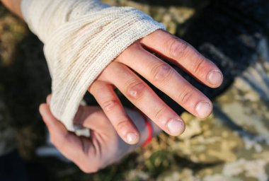 Adam burkulmuş bileğe bandaj yapıyor. Kolum burkuldu. Doğada yaralı bir turist. Yürüyüş.