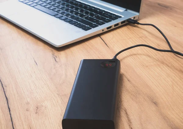 stock image Power bank with usb-c cable is charging laptop . Modern, information technology.