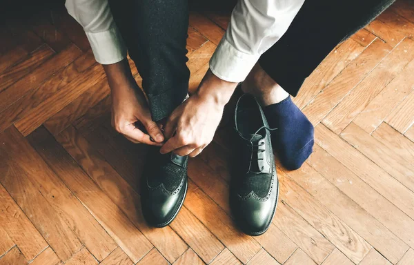 stock image Groom is wearing the shoes. Stylish man getting clothed. Vintage style. Wedding day.