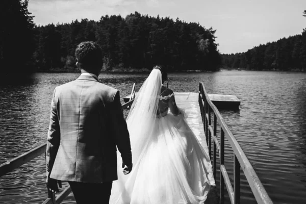 Νύφη Και Γαμπρός Περπατούν Στη Γέφυρα Φωτογραφία Ημέρας Γάμου Κοντά — Φωτογραφία Αρχείου