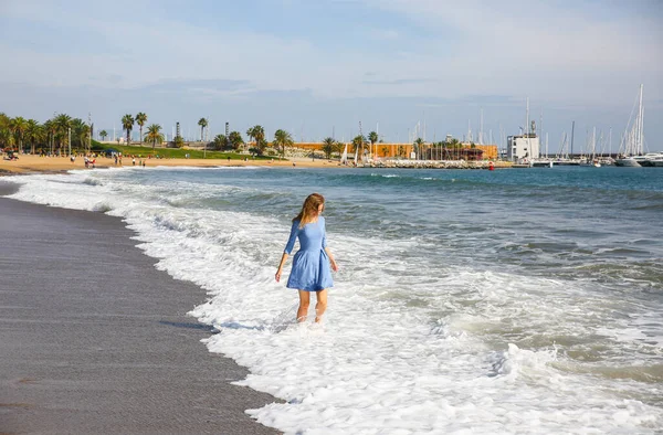 身穿蓝色衣服的漂亮姑娘正在海滩上散步 令人惊奇的夏季照片 女人在海边跳啊跳啊跳快乐和有趣的情绪 假日旅行的概念 温暖的海水 — 图库照片