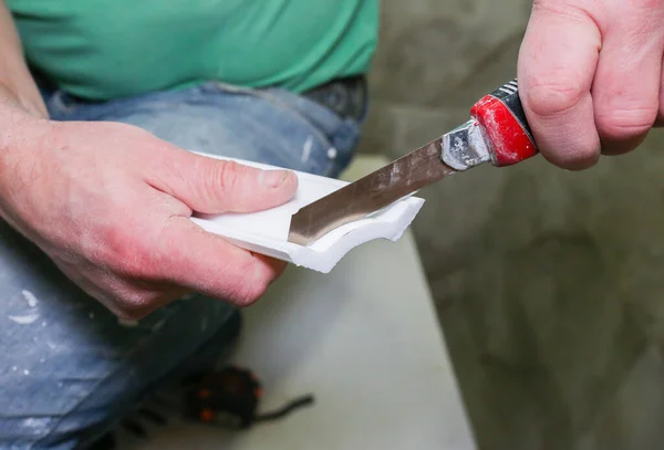 男はユーティリティナイフで石膏ボードを切断しています メンテナンス修理は フラット内の改修を動作します 屋内での修復 乾式壁パネル — ストック写真