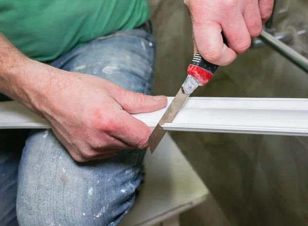 stock image Man is cutting gypsum baseboard with utility knife. Maintenance repair works renovation in the flat . Restoration indoors. Drywall panel.