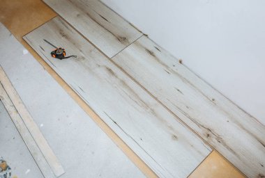 Dairenin döşemesini cilalayın. Bakım onarımı yenileme işidir. Kapalı alanda ahşap parke döşeme onarımı. Mezurayı ve kalemi ölç.