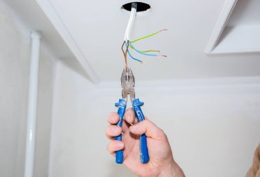 Adam elinde kerpeten tutuyor. Ampul için elektrik yalıtkan. Evde bakım onarımı için yapıştırıcı bant kullanılıyor. İçerideki restorasyon.