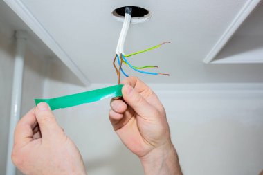 Adam elinde yapışkan bant tutuyor. Ampul için elektrik yalıtkan. Bakım onarımı dairede işe yarıyor. İçerideki restorasyon.