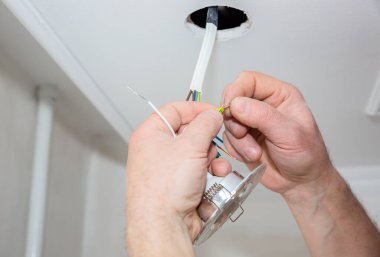 Adam elektrikli yalıtkan yapıyor. Yapışkan bantlı ampul telleri. Bakım onarımı dairede işe yarıyor. İçerideki restorasyon.