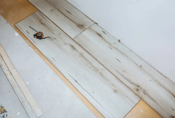 Dairenin döşemesini cilalayın. Bakım onarımı yenileme işidir. Kapalı alanda ahşap parke döşeme onarımı. Mezurayı ve kalemi ölç.