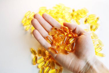 Beyaz ahşap arka planda Omega 3 hapları var. Sağlıklı beslenme takviyeleri. Vejetaryen yemeği için balık yağı..