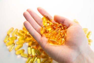 Beyaz ahşap arka planda Omega 3 hapları var. Sağlıklı beslenme takviyeleri. Vejetaryen yemeği için balık yağı..