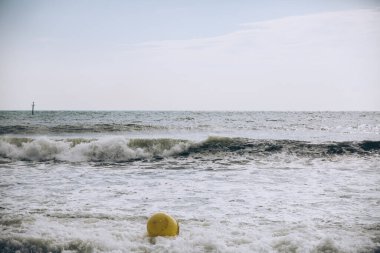 Deniz dalgalarında köpüklü şamandıra. Boş kumsal. Yaz tatili seyahatleri. Fırtınalı okyanus.