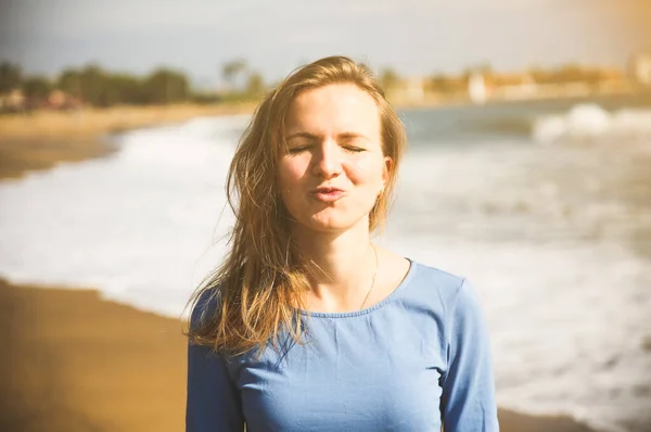 身穿蓝色衣服的漂亮姑娘正在海滩上亲吻 令人惊奇的夏季照片 靠近大海的女人快乐和有趣的情绪 假日旅行概念 — 图库照片