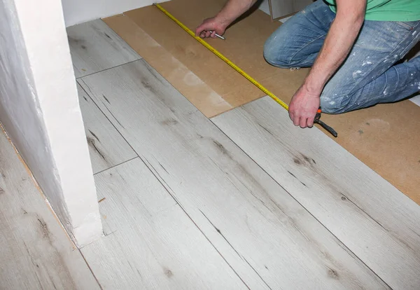 stock image Worker making laminate flooring in apartment. Maintenance repair renovation. Wooden parquet planks indoors.