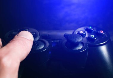 Adam Black Gamepad 'de bilgisayar oyunları oynuyor ve düğmelere ve analoglara basıyor, kapat.