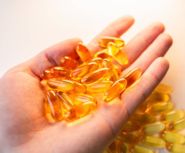 Beyaz ahşap arka planda Omega 3 hapları var. Sağlıklı beslenme takviyeleri. Vejetaryen yemeği için balık yağı..