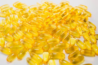 Beyaz ahşap arka planda Omega 3 hapları. Sağlıklı beslenme takviyeleri. Vejetaryen yemeği için balık yağı..