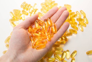 Beyaz ahşap arka planda Omega 3 hapları var. Sağlıklı beslenme takviyeleri. Vejetaryen yemeği için balık yağı..