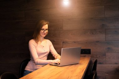 Sosyal medya etkileyicisi, akıllı telefon ve dizüstü bilgisayar kullanarak modern stüdyoda içerik yaratıyor çevrimiçi akışı paylaşıyor. Kız blogcu gülümsüyor ve halka lambasıyla video kaydediyor. Çevrim içi eğitim kursları.