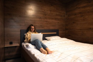 Yatakta dizüstü bilgisayarla çalışan serbest çalışan kadın. İyi iş..