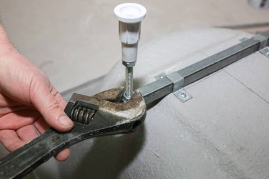 Banyo kurulumu. İşçi ingiliz anahtarıyla daha da güçlendiriyor. Dairede bakım onarımı var. Yenileme işlemi.