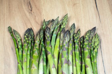 Ahşap arka planda yeşil bir kuşkonmaz sürüsü. Sağlıklı diyet yemekleri. Vejetaryen yemeği..