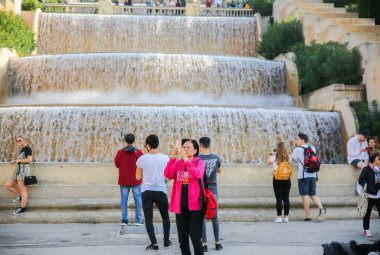 BARCELONA, İspanya - 15 Ekim 2018: Barcelona Katalonya Ulusal Sanat Müzesi. İnsanlar fıskiyenin yanında fotoğraf çekiyor. Şehirde yürüyen turistler.