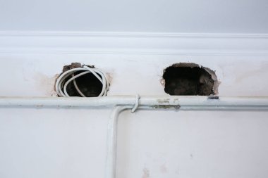 Evin duvarında tadilat var. Beyaz boyalı delikler. Yenileme işlemi. Evde boru var..