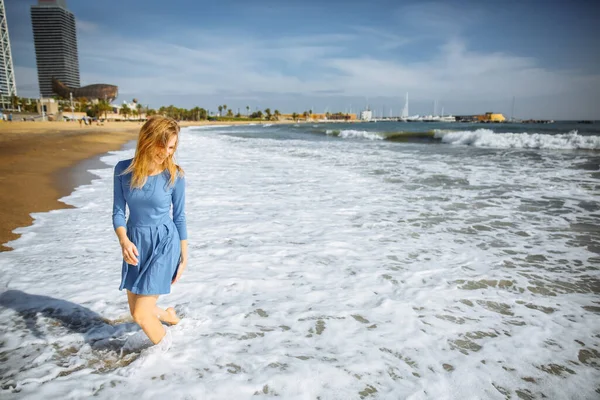 身穿蓝色衣服的漂亮姑娘正在海滩上散步 令人惊奇的夏季照片 女人在海边跳啊跳啊跳快乐和有趣的情绪 假日旅行的概念 温暖的海水 — 图库照片