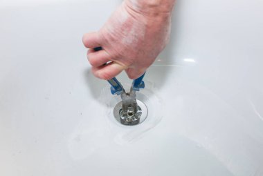 Banyo kurulumu. İşçi kerpetenle drenaj yapıyor. Dairede bakım onarımı var. Yenileme işlemi.